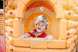 Cute child playing in toy house