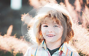 Cute child portrait. Happy boy child is smiling enjoying life. Portrait of young boy in nature, park or outdoors