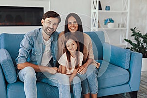 Cute child posing with her parents for family portrait