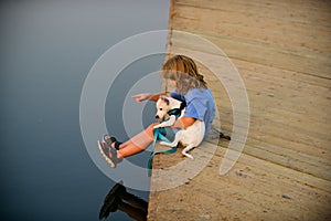 Cute child and puppy playing outside. Carefree childhood. Protection domestic animal.