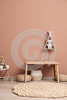 Cute child room interior with furniture, toys and wigwam shaped shelf on pink wall