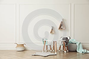 Cute child room interior with furniture, toys and wigwam shaped shelves on white wall