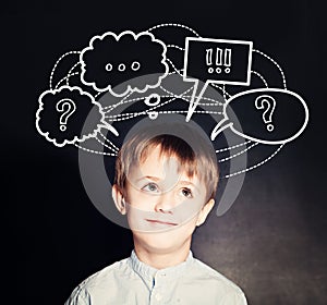 Cute Child School Boy on Blackboard Background with question marks