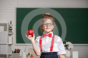 Cute child at school. Kid is learning in class on background of blackboard. Educational process.