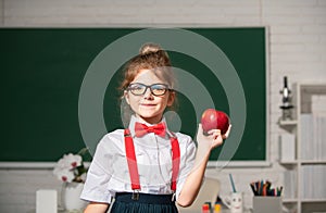 Cute child at school. Kid is learning in class on background of blackboard. Educational process.