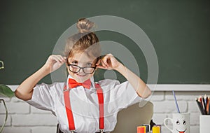 Cute child at school. Kid is learning in class on background of blackboard. First day at school.