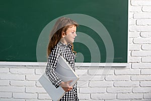 Cute child at school. Kid is learning in class on background of blackboard. Genius child, knowledge day.