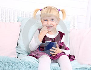 Cute child sit in chair and eat cookies