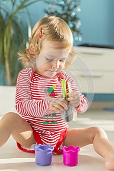 Cute child sits barefoot on the floor