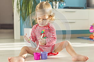 Cute child sits barefoot on the floor