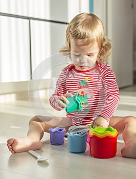 Cute child sits barefoot on the floor