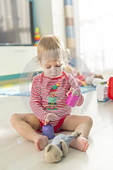 Cute child sits barefoot on the floor