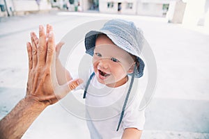 Cute child son giving high five to father.