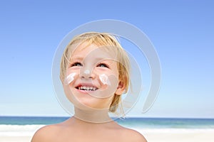 Cute child with sunscreen at the beach