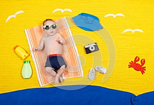 Cute child in swimming trunks is lying on a towel. Summer vacation