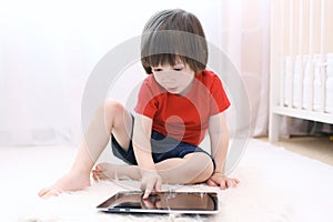 Cute child with tablet computer at home