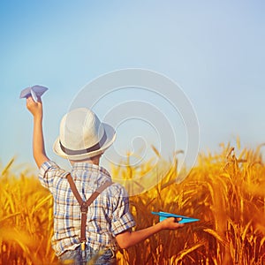 Cute child walking in the wheat golden field on a sunny summer day. Square.