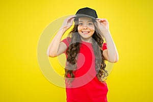 Cute child wear cap or snapback hat. Little girl wearing baseball cap. Summer sun protection cap. Girl long curly hair