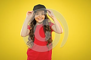 Cute child wear cap or snapback hat. Little girl wearing baseball cap. Summer sun protection cap. Girl long curly hair