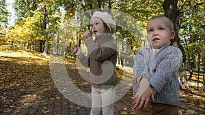 Cute children clapping and singing in autumn park