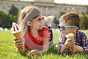 Cute children with delicious ice creams on grass