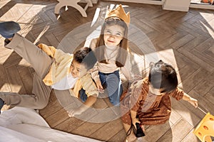 Cute children of different races play together. Asian sibling and caucasian girl are messing around in the bedroom on the floor. photo