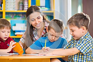 Cute children drawing with teacher at preschool class