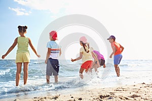 Cute children enjoying sunny day at beach. Summer camp