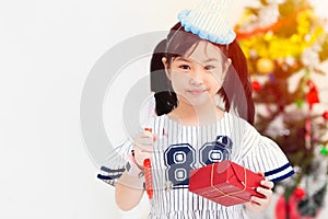 Cute children girl hand holding gift box for new year