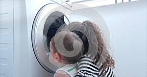 Cute Children Looks Inside the Washing Machine. Cylinder Spinning Machine. Concept Laundry Washing Machine, Industry