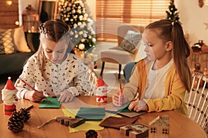 Cute children making Christmas greeting card at home