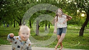 Cute children making rhythmical movements outdoors. Brother and sister dancing