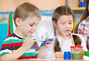 Cute children painting at kindergarten