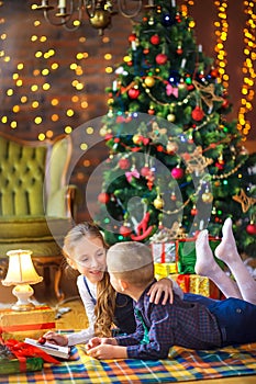 Cute children play lying on the floor in a festively decorated room