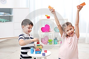 Cute children playing with colorful blocks