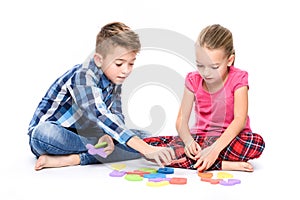 Cute children playing with large colorful alphabet letters on white background. Kids speech therapy concept. Dyslexia.
