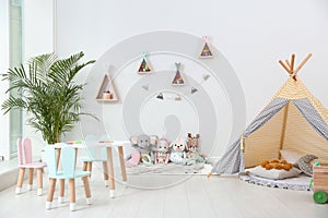 Cute children`s room interior with teepee tent and little table