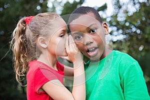 Cute children sharing gossip outside