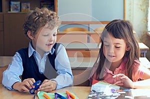 Cute children sitting at the desk in the classroom. Concept of the first lesson in elementary school.