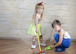 Cute children using toy broom and dustpan