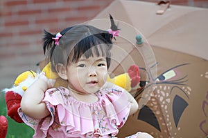 Cute Chinese baby girl play plush toy on the lawn