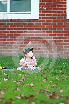 Cute Chinese baby girl wears glasses on the lawn