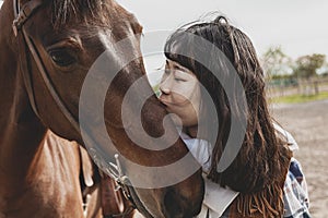 Cute chinese cowgirl while taking care of her horse