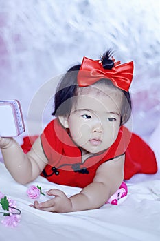 Cute Chinese little baby in red cheongsam have fun