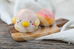 Cute Chinese Pastry or moon cake stuffed with salted egg yolk on wood plate