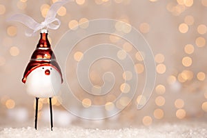 Cute Christmas bird adornment with bokeh of yellow and white christmas lights