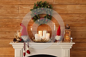 Cute Christmas gnomes and festive decorations on mantelpiece in room