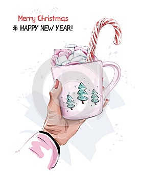 Cute christmas style cup with marshmallow and candy cane. Female hand holding cup. New Year style.