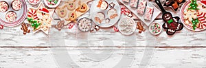 Cute Christmas sweets and cookie top border over a rustic white wood banner background