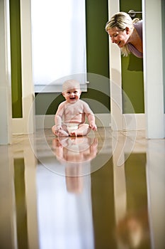 Cute chubby baby on floor laughing at mom photo